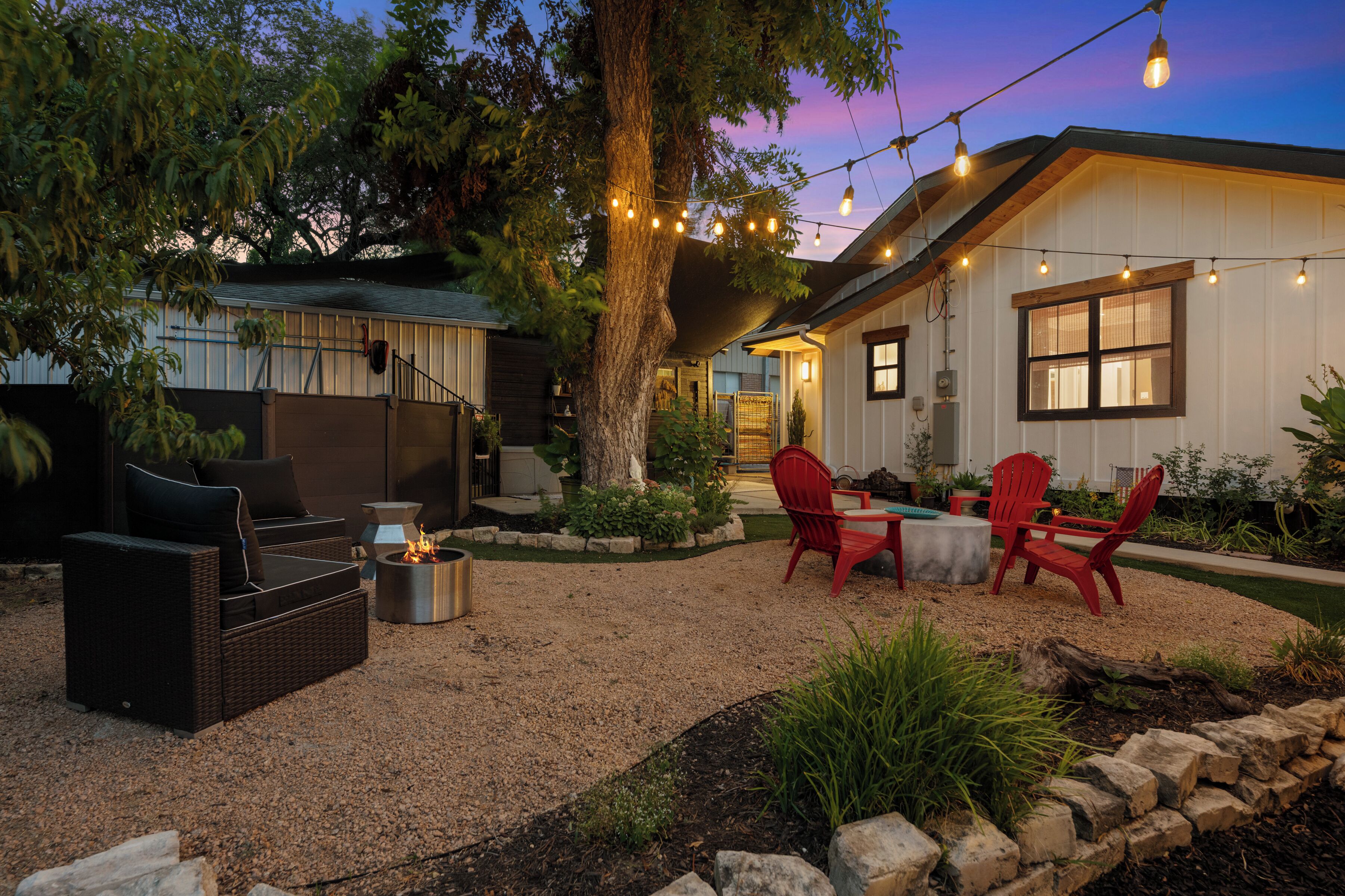 A patio area with outdoor furniture, a fire pit, and string lights.