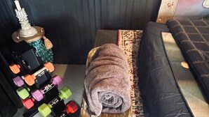 A small, cozy room with a bench, a rug, and a decorative item resembling a Christmas tree.