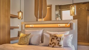 A modern bedroom with a large bed, bedside lamps, a mirror, and a wooden headboard.
