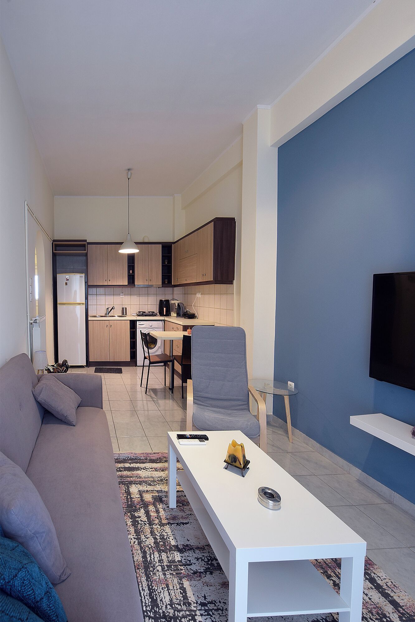 A modern living room with a sofa, a coffee table, and a TV.