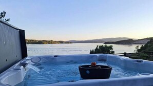 Un bain à remous avec vue sur un lac et des collines.