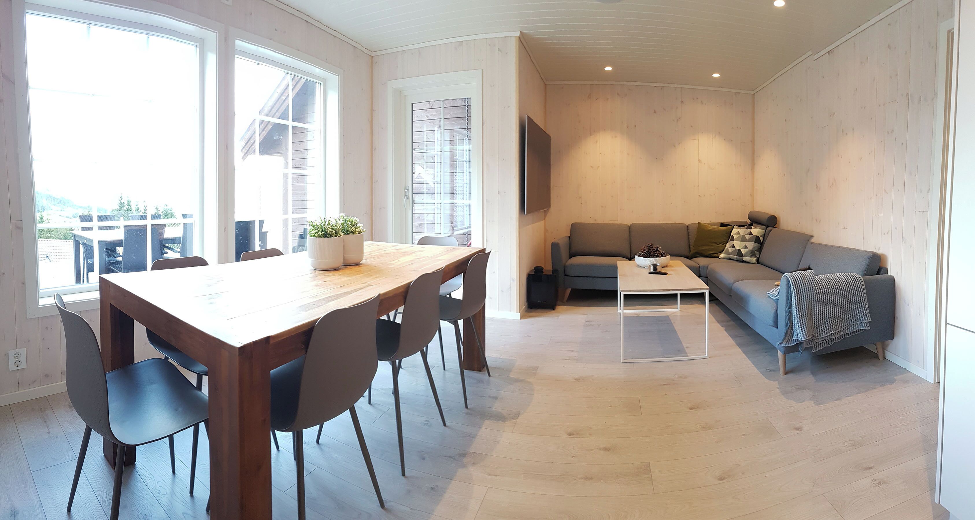 Un salon moderne avec une table à manger en bois, des chaises, un canapé et une table basse.