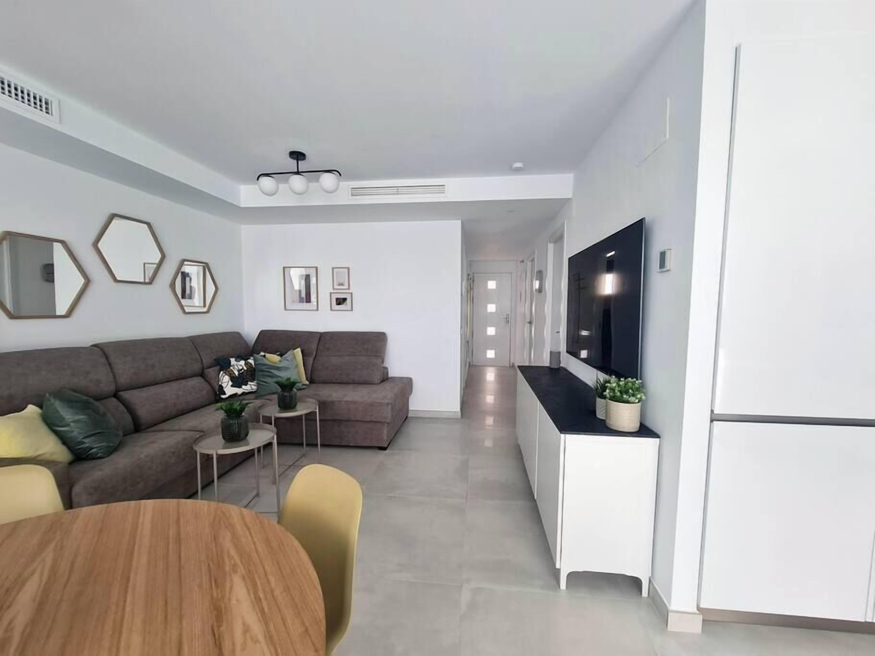 Ein modernes Wohnzimmer mit einer Couch, einem Couchtisch und einem Fernseher.
