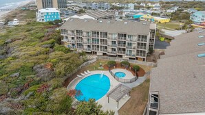 A multi-story hotel with a swimming pool, located near a beach. - Island Beach and Racquet Club B104: Oceanfront Condo with Views, Community Amenities (Atlantic Beach)