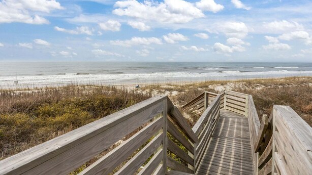 A wooden boardwalk leading to a beach with a clear sky and ocean view. - Island Beach and Racquet Club B104: Oceanfront Condo with Views, Community Amenities (Atlantic Beach)