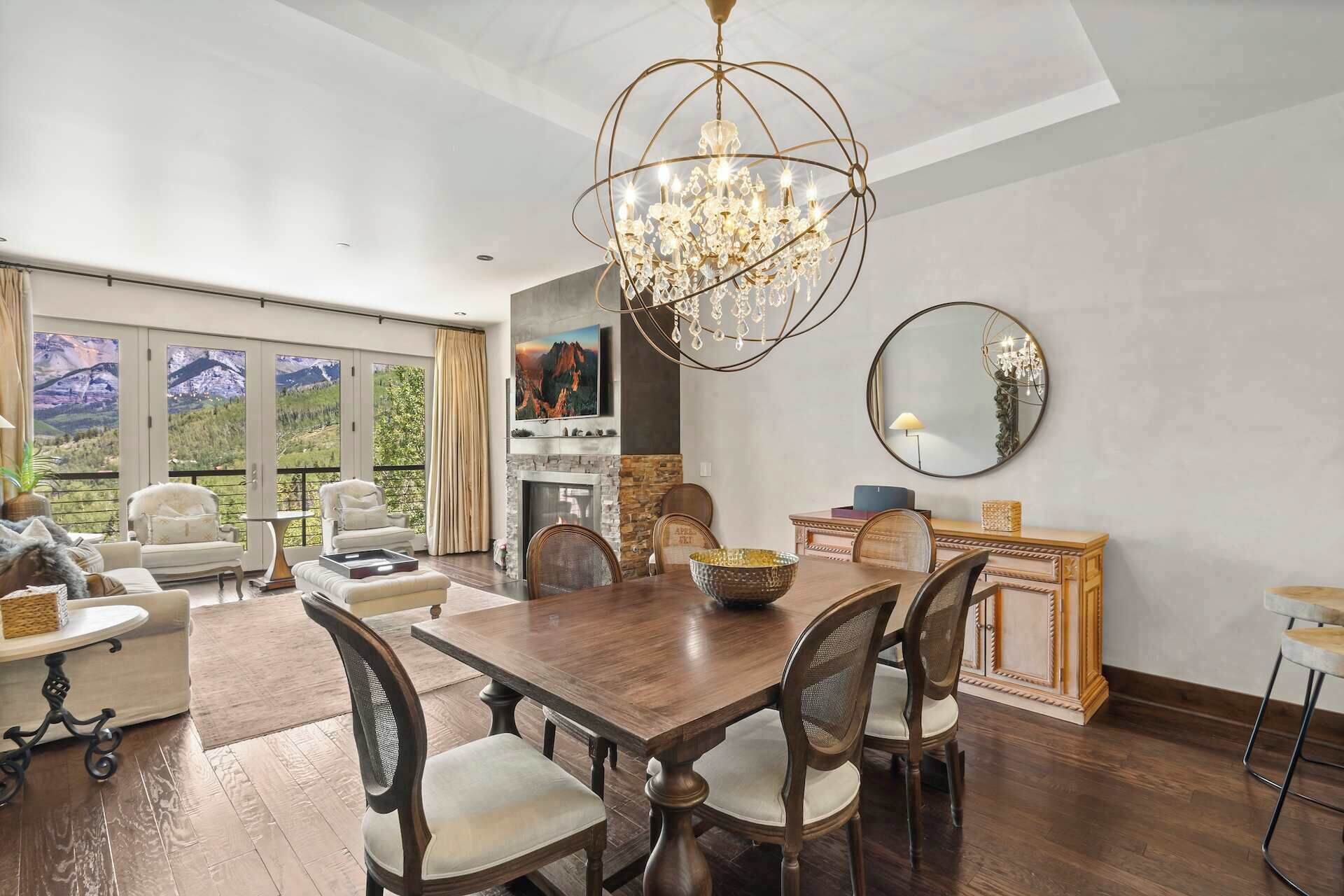 A dining area with a chandelier, wooden dining table, and chairs.