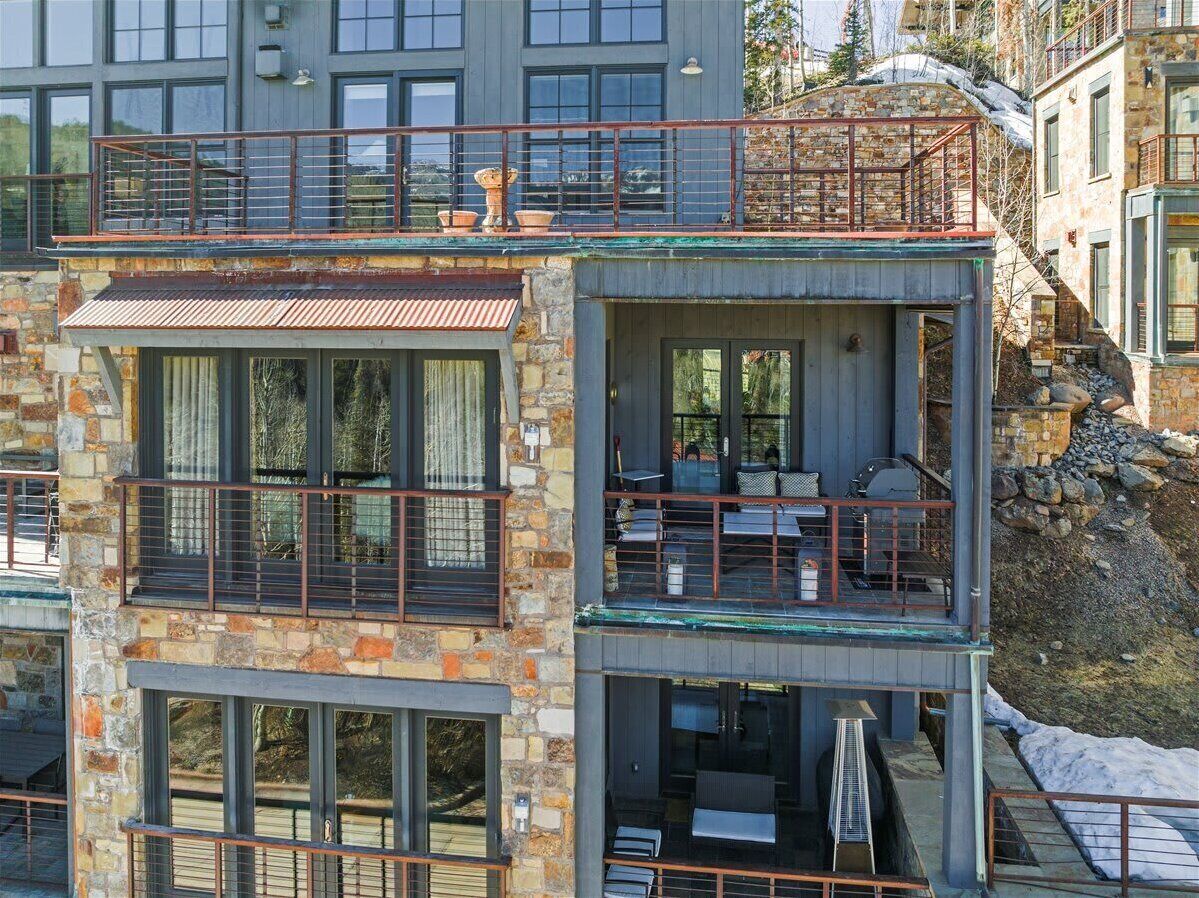 Un immeuble à plusieurs étages, doté de balcons, de grandes fenêtres et d’une façade en pierre.