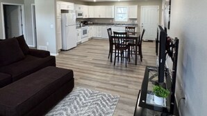 A modern apartment with a living room, dining area, and kitchen. - Cozy West Duplex (Seymour)