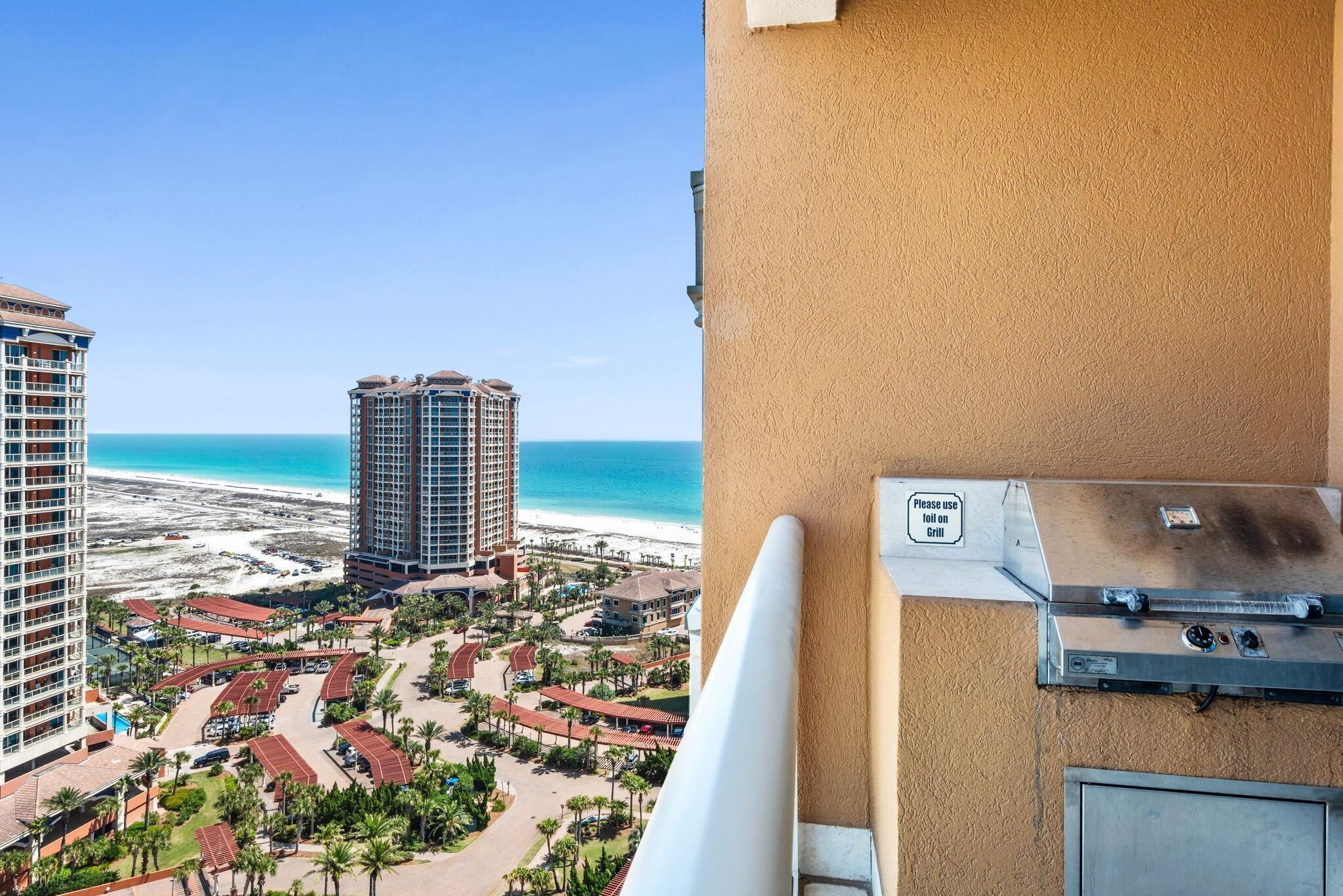 A high-rise hotel with a view of the beach and ocean.