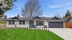 A single-story house with a front garage, a blue door, and a well-maintained lawn. - Modern, fully updated 4-BR house in cul-de-sac (Vancouver)