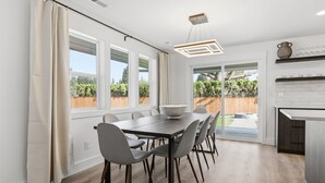 A modern kitchen with a dining area, large windows, and a view of the backyard. - Modern, fully updated 4-BR house in cul-de-sac (Vancouver)