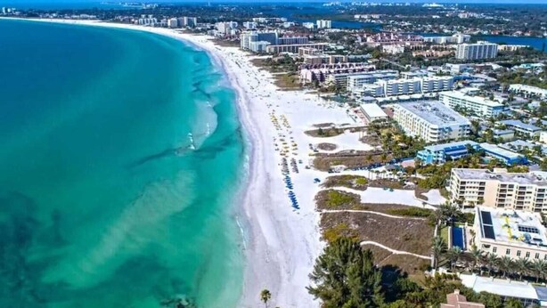 Un paisaje urbano costero con playa, edificios y cielo despejado.