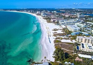 Eine Küstenstadt mit Strand, Gebäuden und blauem Himmel.