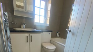 A compact bathroom with a toilet, a sink, and a cabinet.