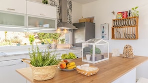 Eine moderne Küche mit Holzarbeitsplatte, einem Glashaus und diversen Küchenutensilien.