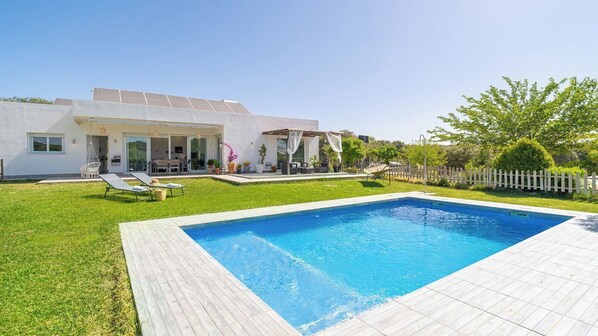 A modern house with a swimming pool, a patio with lounge chairs, and a garden. - La Carraca Archidona by Ruralidays (Málaga)