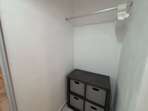 A corner of a room with a white wall, a dark-colored cabinet with multiple drawers, and a metal rod with a white towel. - Charming 2-bedroom apartment with AC in San Miguel de Cozumel (San Miguel de Cozumel)