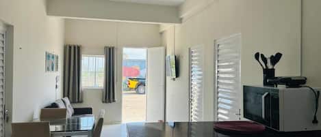 A modern kitchen with a dining area, a microwave, and a view of the outside.
