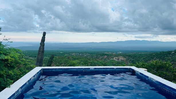A pool with a view of a landscape and mountains.