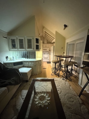 A compact living space with a kitchenette, a dining area, and a seating area with a coffee table.