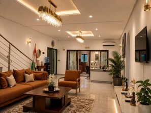 Ein modernes Wohnzimmer mit einer Couch, einem Couchtisch und Zimmerpflanzen.