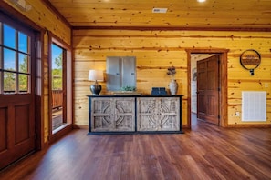 A wooden interior with a reception desk, a lamp, and a wall-mounted sign. - 8-Bedroom Log Cabin in Pigeon Forge with Indoor Pool & Outdoor Theater (Sevierville)