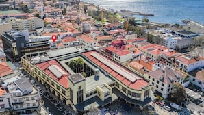 En stadsbild från en kuststad med en framträdande byggnad som har ett rött tak, ett väl synligt klocktorn och en röd markering som anger platsen.