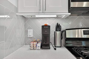 A kitchen with a coffee maker, a stainless steel appliance, and a set of containers on the counter. - Houston 3BR Home w/ Parking - Near Top Attractions (Houston)