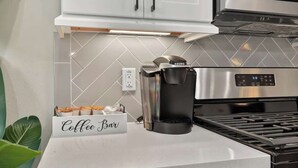 Una cocina con cafetera, letrero de barra de café y estufa.