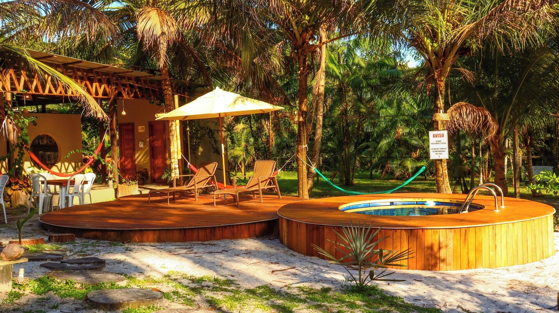 A pool area with lounge chairs, a wooden deck, and a sign indicating a 2.5-hour wait time.