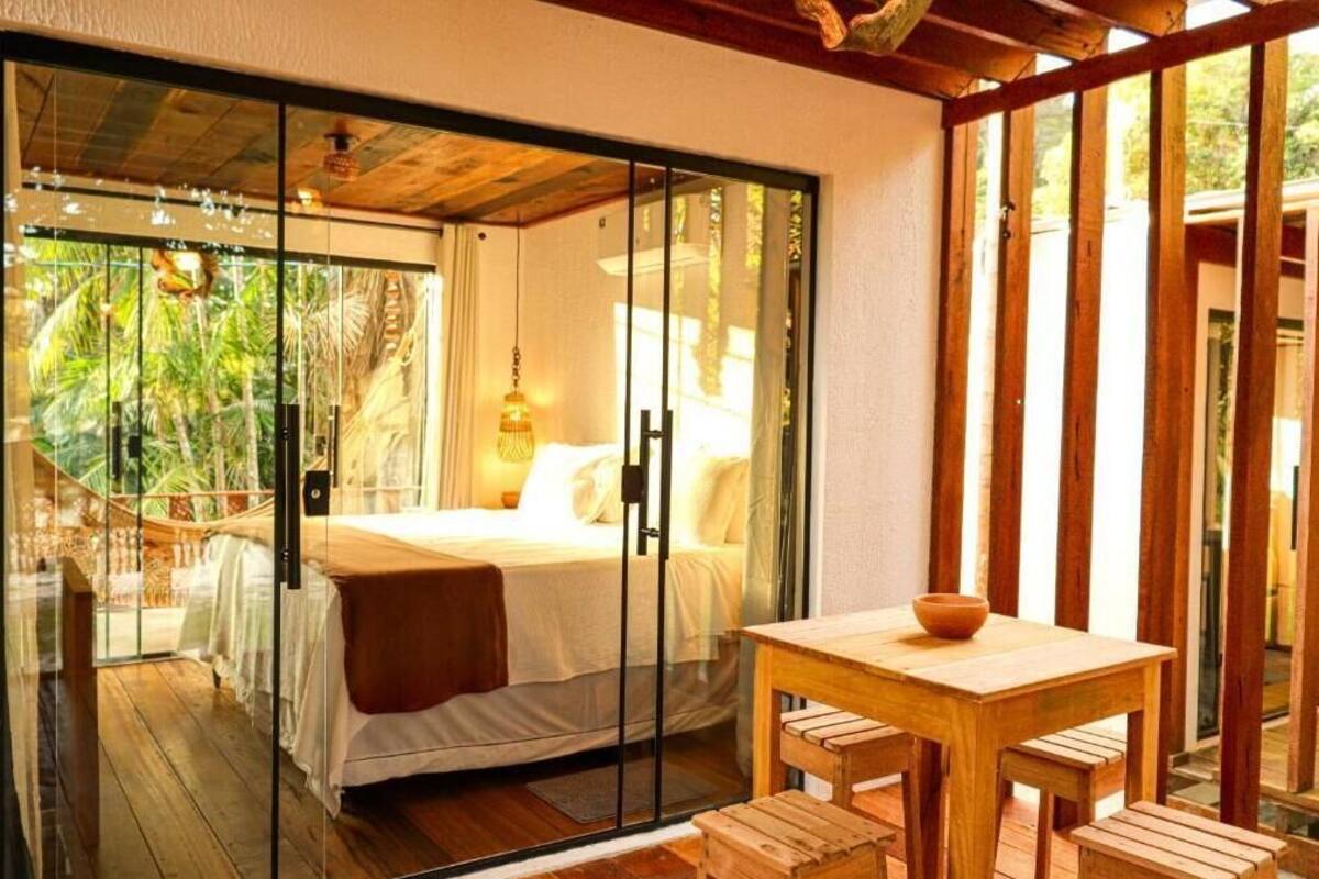 Un dormitorio con cama, una mesa de madera y un banco.
