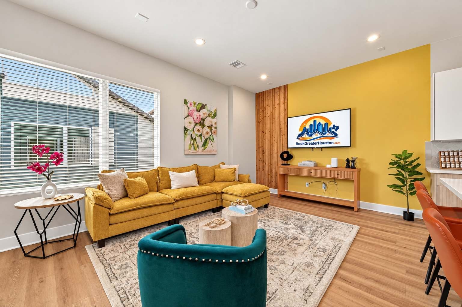 A modern living room with a yellow sofa, a teal armchair, and a wooden coffee table.