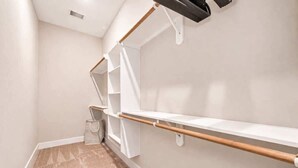 A hallway with a white wall, a wooden handrail, and a white floor. - Texas-Style 3BR Houston + Games (Houston)