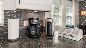 A kitchen with a coffee maker, a paper towel holder, and a coffee bar organizer. - Beachside 3BR w/ New Hot Tub & Huge Backyard (Largo)