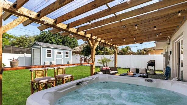 A hot tub under a wooden pergola with a backyard patio area. - Beachside 3BR w/ New Hot Tub & Huge Backyard (Largo)