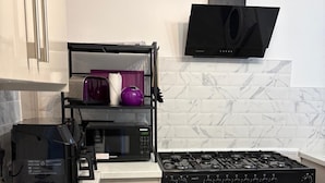 A compact kitchen with a gas stove, a microwave, and a built-in oven. - Coastal Retreat, Rhos-on-Sea, 1-Min Walk to Beach (Rhos on Sea)