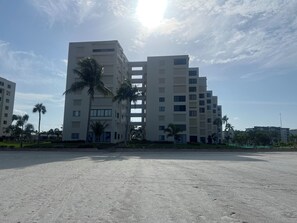 A multi-story building with a flat facade and a central courtyard. - Vacation Destination! White sand beaches and ocean breezes! (Fort Myers Beach)