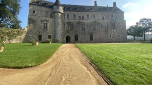 A large stone castle with a central entrance, surrounded by well-maintained lawns and a clear sky. - Ty Bihan - PLEUMEUR GAUTIER (PLEUMEUR GAUTIER)