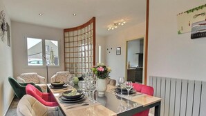 A dining area with a long table, chairs, and a decorative partition. - Ty Bihan - PLEUMEUR GAUTIER (PLEUMEUR GAUTIER)
