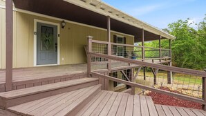 A wooden deck leading to a covered porch with a door and a number '39' on the wall. - Answered Prayers Main House-Step out to a peaceful morning or star gaze at night (Kingston)