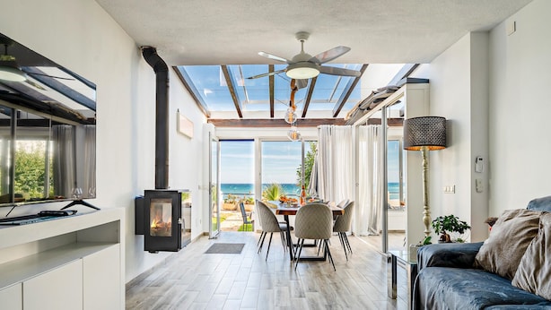 Eine moderne Küche mit Einbauherd, ein Essbereich mit Meerblick und eine gemütliche Sitzecke mit Deckenventilator.