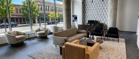 A spacious lobby with a large sofa, armchairs, a coffee table, and a patterned wall.