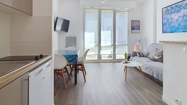 Um apartamento moderno com cozinha, sala de jantar, sala de estar e varanda.