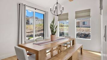 Un coin repas avec une table en bois, des bancs et une plante en pot.
