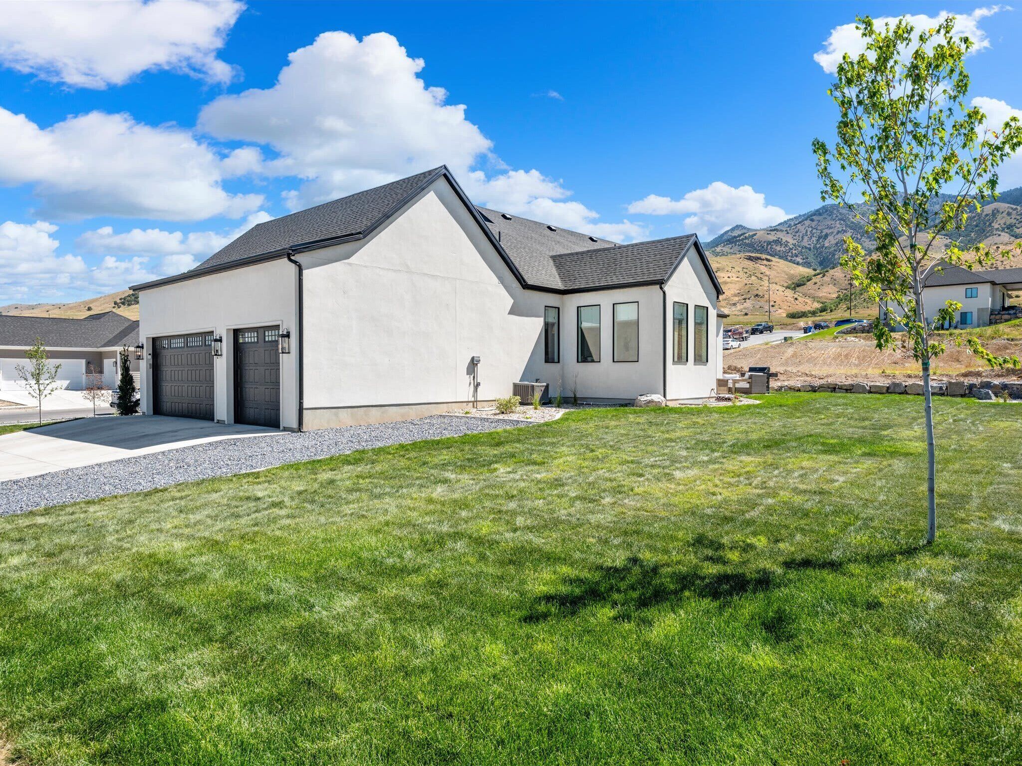 Ein modernes, zweistöckiges Haus mit Garage, gepflegtem Rasen und blauem Himmel.