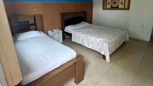Ein Schlafzimmer mit zwei Betten, einer Klimaanlage, einem Deckenventilator und einer Wanddekoration.