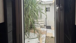 Une fenêtre donnant sur une maison et un jardin.
