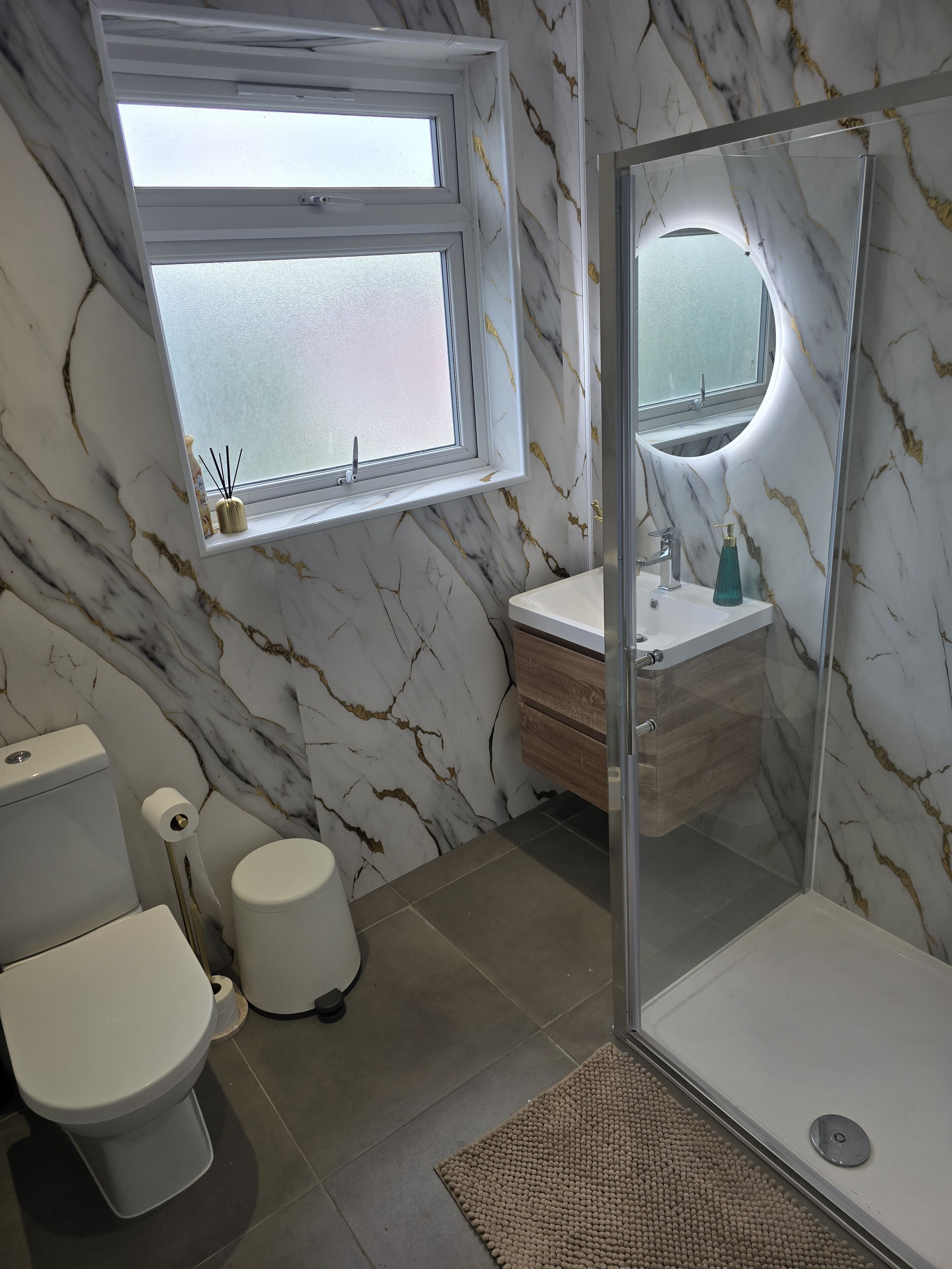 A bathroom with a toilet, sink, and shower.
