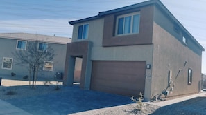 A modern two-story house with a garage, a driveway, and a small tree in the front yard. - Amazing 5-bedroom house with AC in welcoming Las Vegas (Las Vegas)