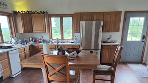 Una cocina con armarios de madera, una isla grande y una zona de comedor con dos sillas.